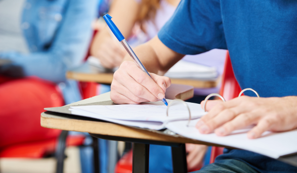 student writing on a notebook