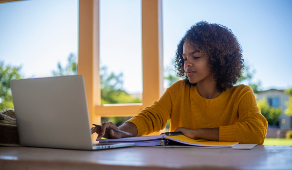 female student sitting at a laptop with a look of concentration